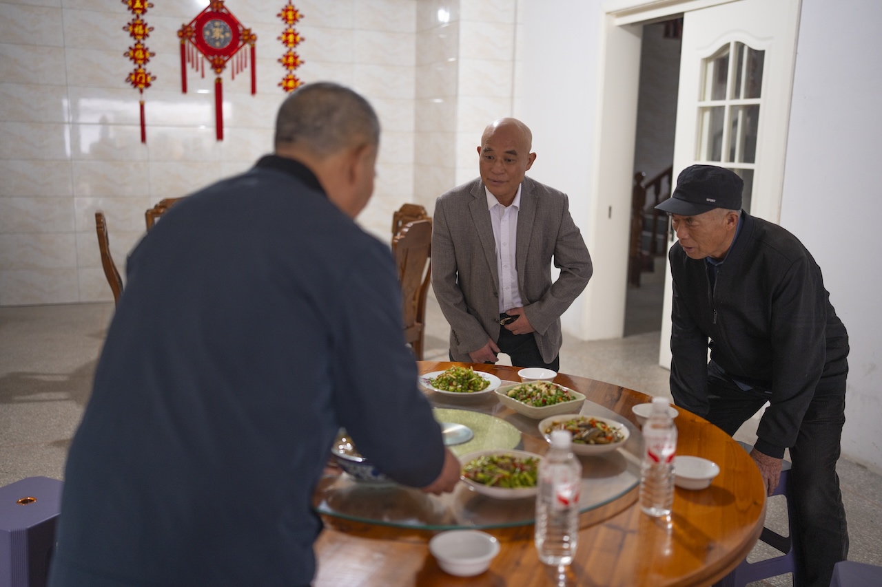 The founder’s uncle and family gathered around the table in Guangdu Cun.